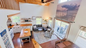 A compact living space with a kitchen, dining area, and seating area. - Tranquility Heights: Deck, 3.5 acres, Darts, Movie Room, Desk w/Printer (Ozark)