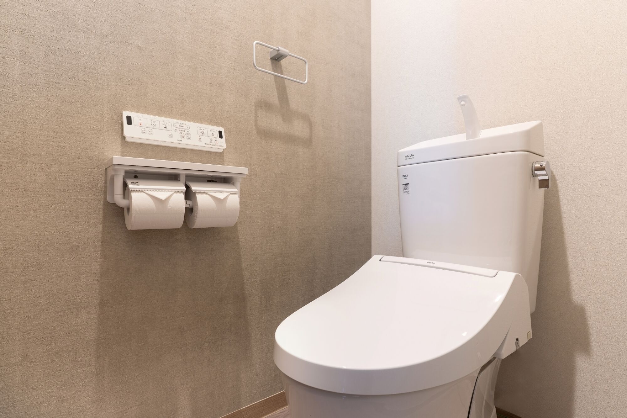 Des toilettes modernes dotées d’un panneau de commande situé au-dessus.