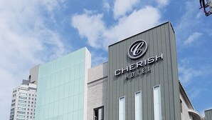 Exterior de l'hotel Cherish amb un senyal que indica disponibilitat de places d'aparcament.