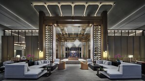 A modern lobby with a central seating area, bookshelves, and a chandelier. - Primus Hotel Xuzhou Dalong Lake (Xuzhou)