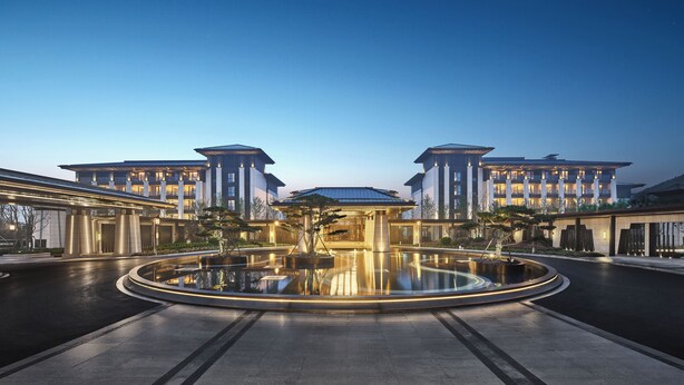 A modern hotel with a central courtyard, multiple floors, and a reflective pool. - Primus Hotel Xuzhou Dalong Lake (Xuzhou)