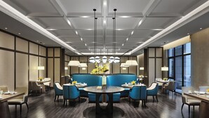 A modern dining area with a central round table, blue upholstered seating, and pendant lighting. - Primus Hotel Xuzhou Dalong Lake (Xuzhou)