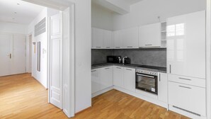 Una cocina moderna con armarios blancos, una encimera negra y un horno empotrado.