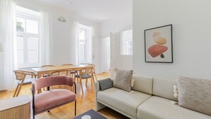 Amplia sala de estar con comedor, sofá y un cuadro en la pared.