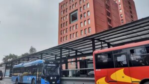 A bus station with a covered shelter and a red building in the background. - Cozy apartment close to everything CDMX! (Ciudad de México)