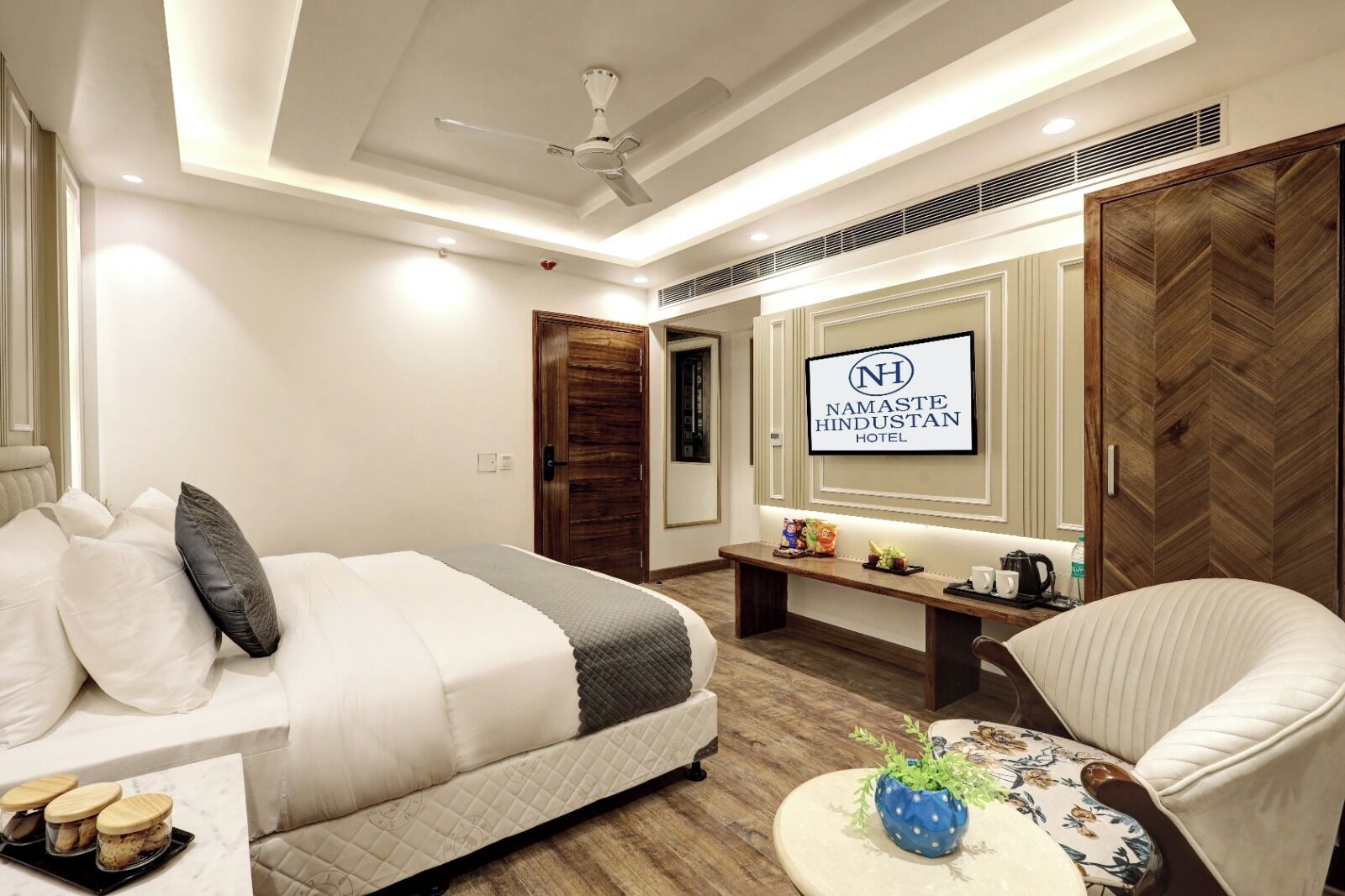 Une chambre d’hôtel comprenant un lit, un coin salon avec une table basse, une télévision et une armoire.