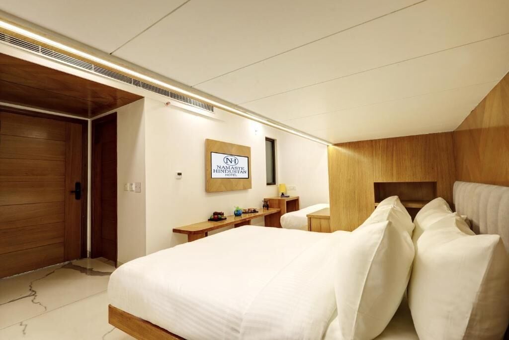 A hotel room with a bed, bedside table, and a sign indicating the hotel name.