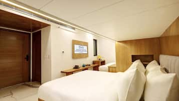 A hotel room with a bed, bedside table, and a sign indicating the hotel name.