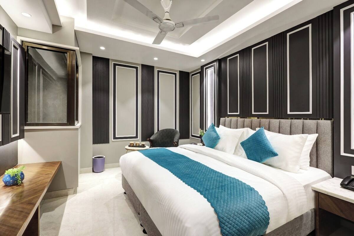 Um quarto moderno com uma cama grande, um ventilador de teto e uma mesa de cabeceira.