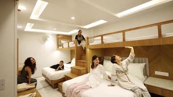 Una habitación de hotel moderna con literas, una escalera y un área de descanso.