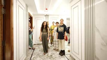 A hallway with white walls and a marble floor.
