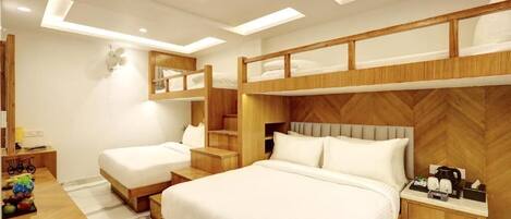 A modern hotel room with a large bed, a smaller bed, a desk with a chair, and a mirror.