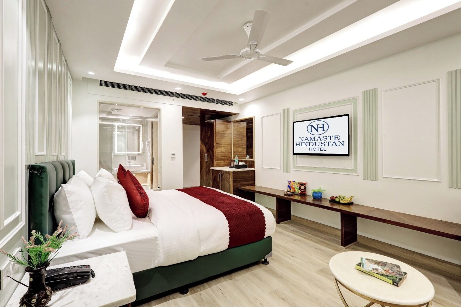 A modern hotel room with a bed, bedside table, and a bench.