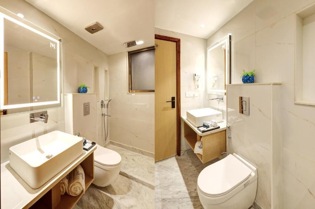 A modern bathroom with a large mirror, a sink, a toilet, and a shower area.