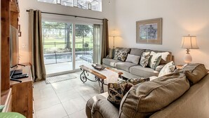 Ein geräumiges Wohnzimmer mit Sofa, Couchtisch und Deckenventilator.