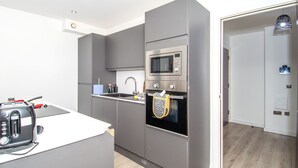 Una cocina moderna con armarios grises, un microondas integrado y un horno.