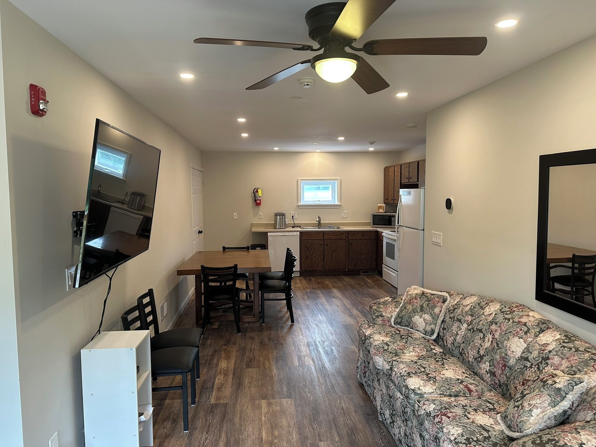 Un espacio habitable compacto con comedor, kitchenette y sofá.