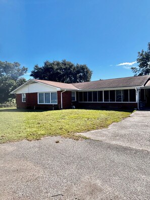 A two-story house with a covered porch and a well-maintained lawn. - Spacious family beach home wgrill,arcade, pool table,pingpong, gameroom,fire pit (Gulfport)
