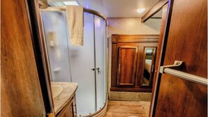 Une petite salle de bain comprenant une douche, des toilettes et un meuble-lavabo.