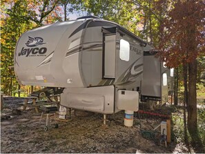 A Jayco Eagle Series RV parked in a wooded area.