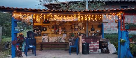 A rustic outdoor market stall with a variety of items for sale, including kitchenware and decorative objects.
