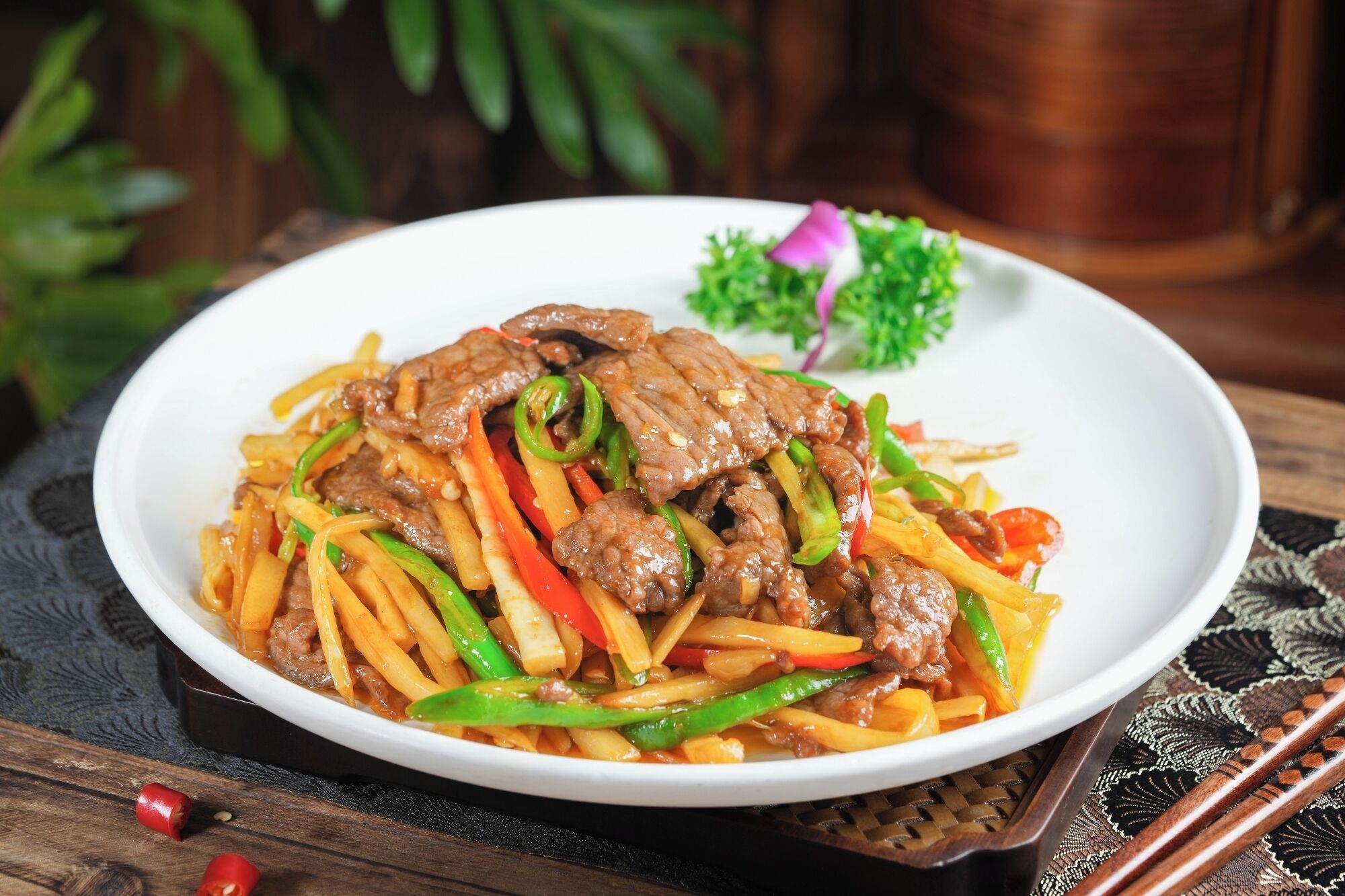 A plate of beef stir-fry with vegetables on a white plate.