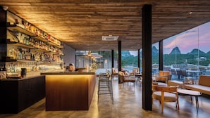 A modern bar with a wooden ceiling and a view of mountains. - YangShuo Percent Hotel (Guilin)