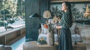 A modern interior with a large window, a round table with a vase of dried flowers, and a sofa. - YangShuo Percent Hotel (Guilin)