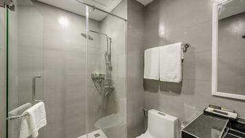 Un bagno moderno con doccia vetro, toilette e lavandino.