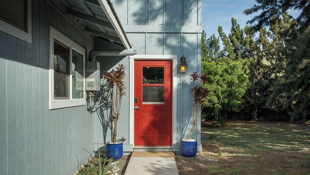 A house with a red door, a window, and a small porch area. - Sunset Orchard- Sunny side of Waimea, close to beaches! (Waimea)