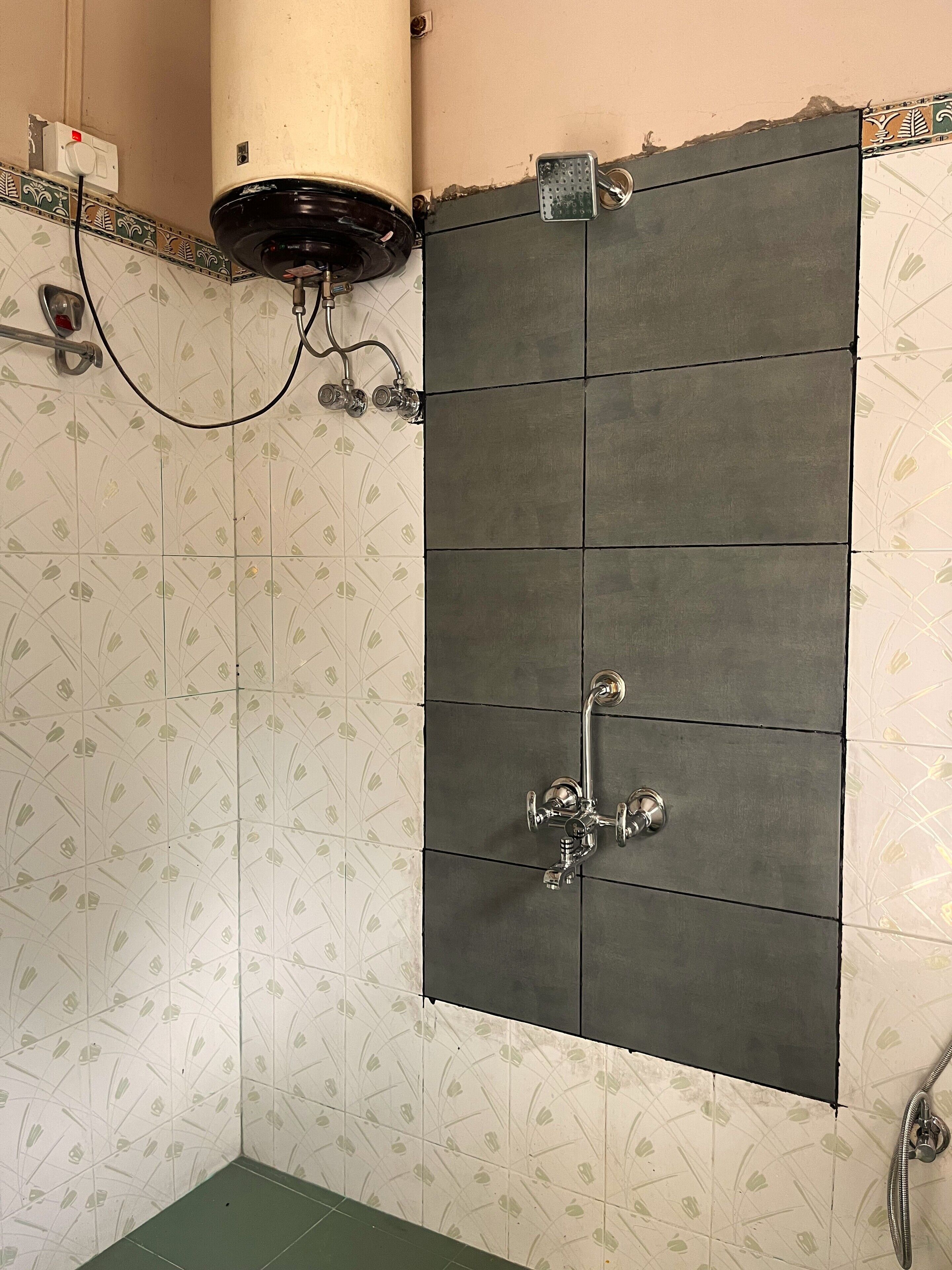 A bathroom with a shower area, a toilet, and a sink.