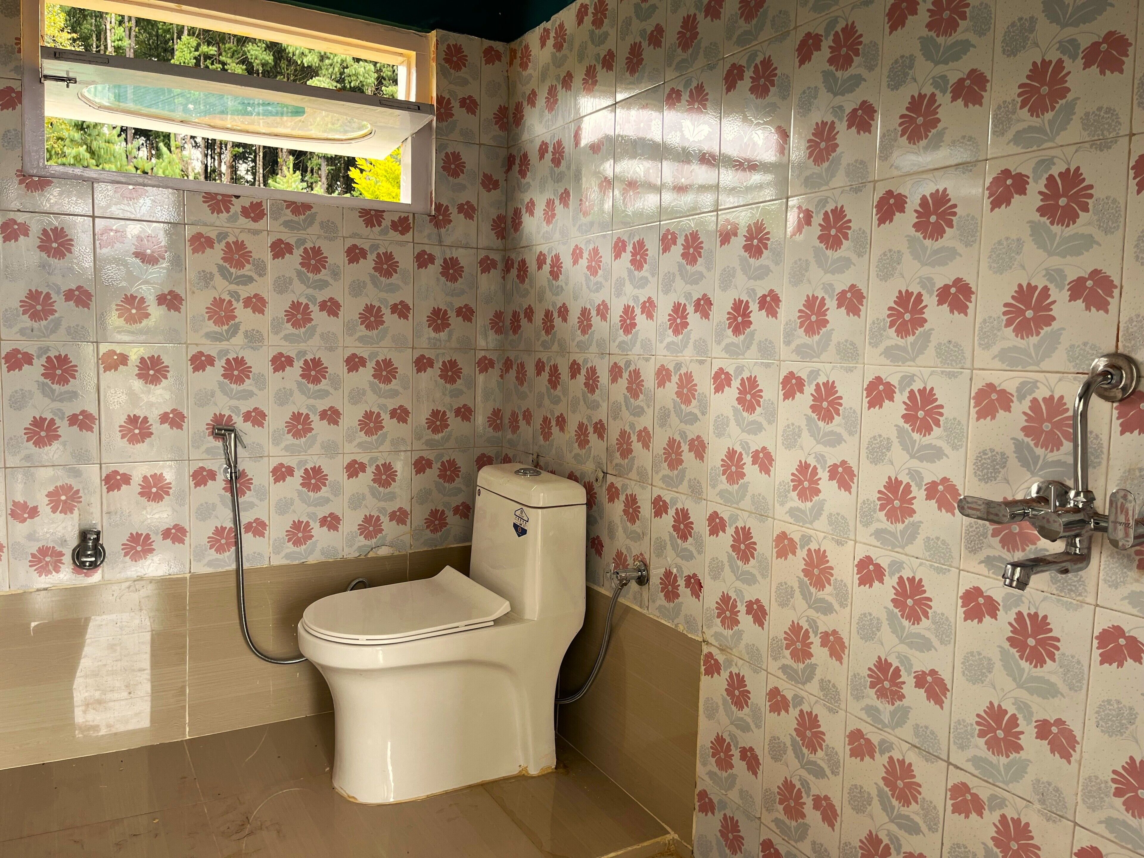 Un baño con inodoro, ducha y ventana.