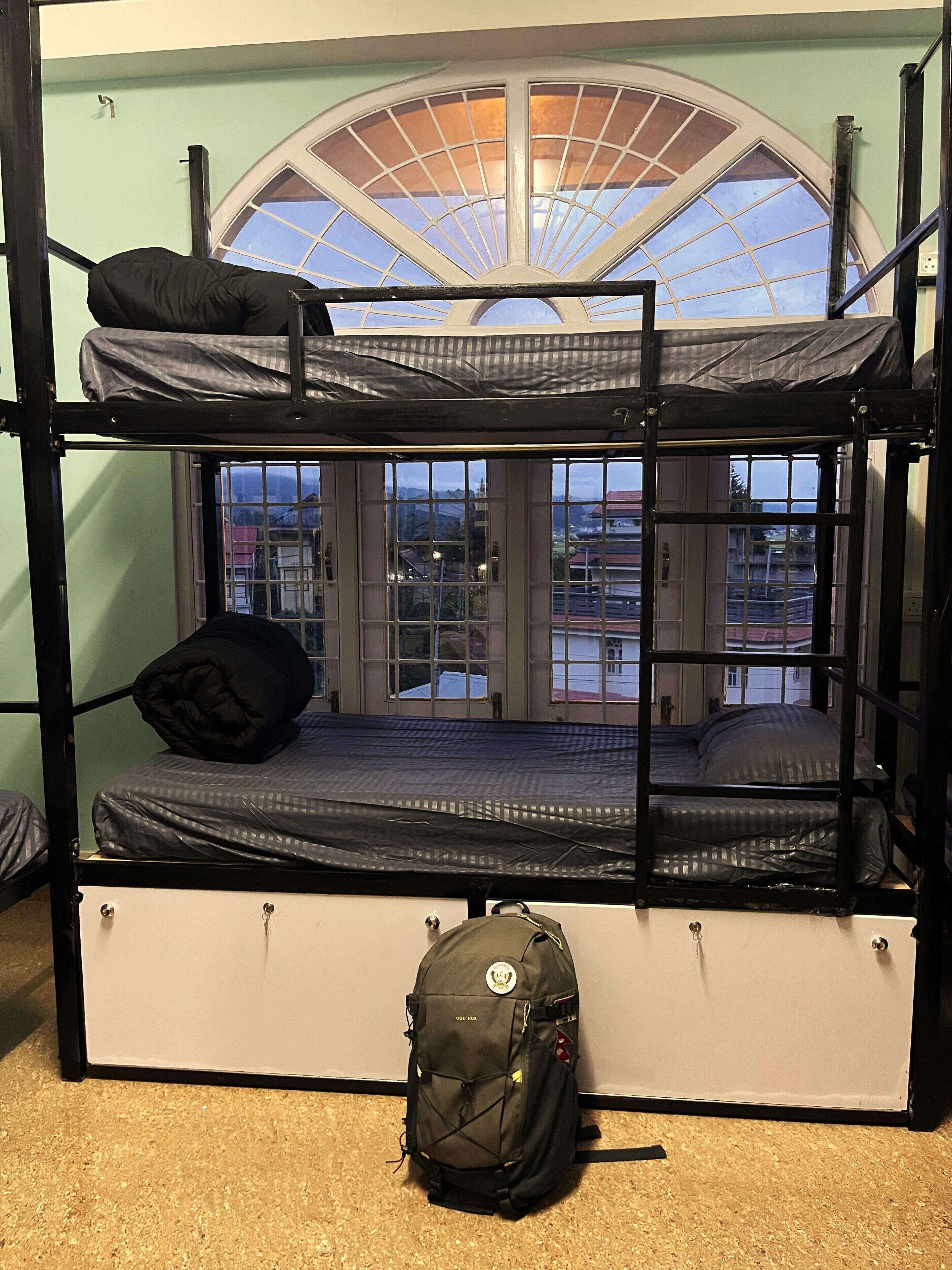 A bunk bed room with a skylight, a window, and a backpack on the floor.