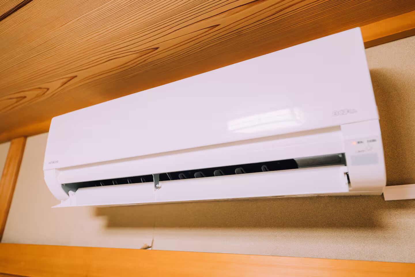 Un equipo de aire acondicionado blanco, fijado a la pared, con panel de control y nombre de marca visible.
