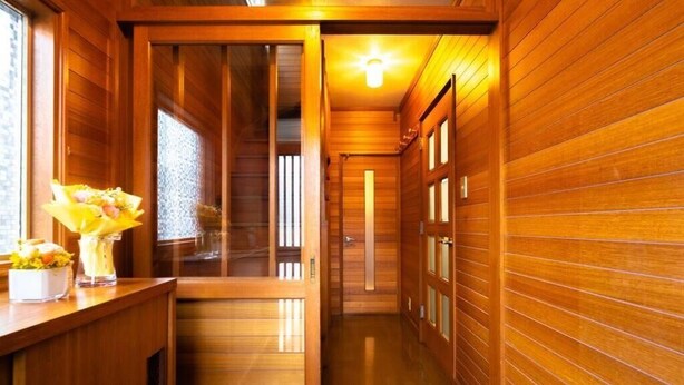 A wooden interior hallway with a reception desk and a staircase leading to another level. - Stay in Miyashita (Asahikawa)