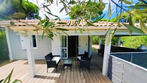 A covered patio with a pergola, outdoor furniture, and a view of a house.