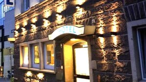 A hotel with a stone facade and illuminated windows. - City Hotel (Boeblingen)