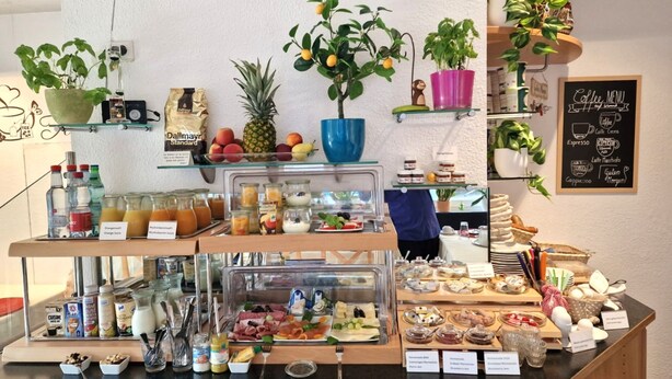 A breakfast buffet with various food items, drinks, and a coffee menu on the wall. - City Hotel (Boeblingen)