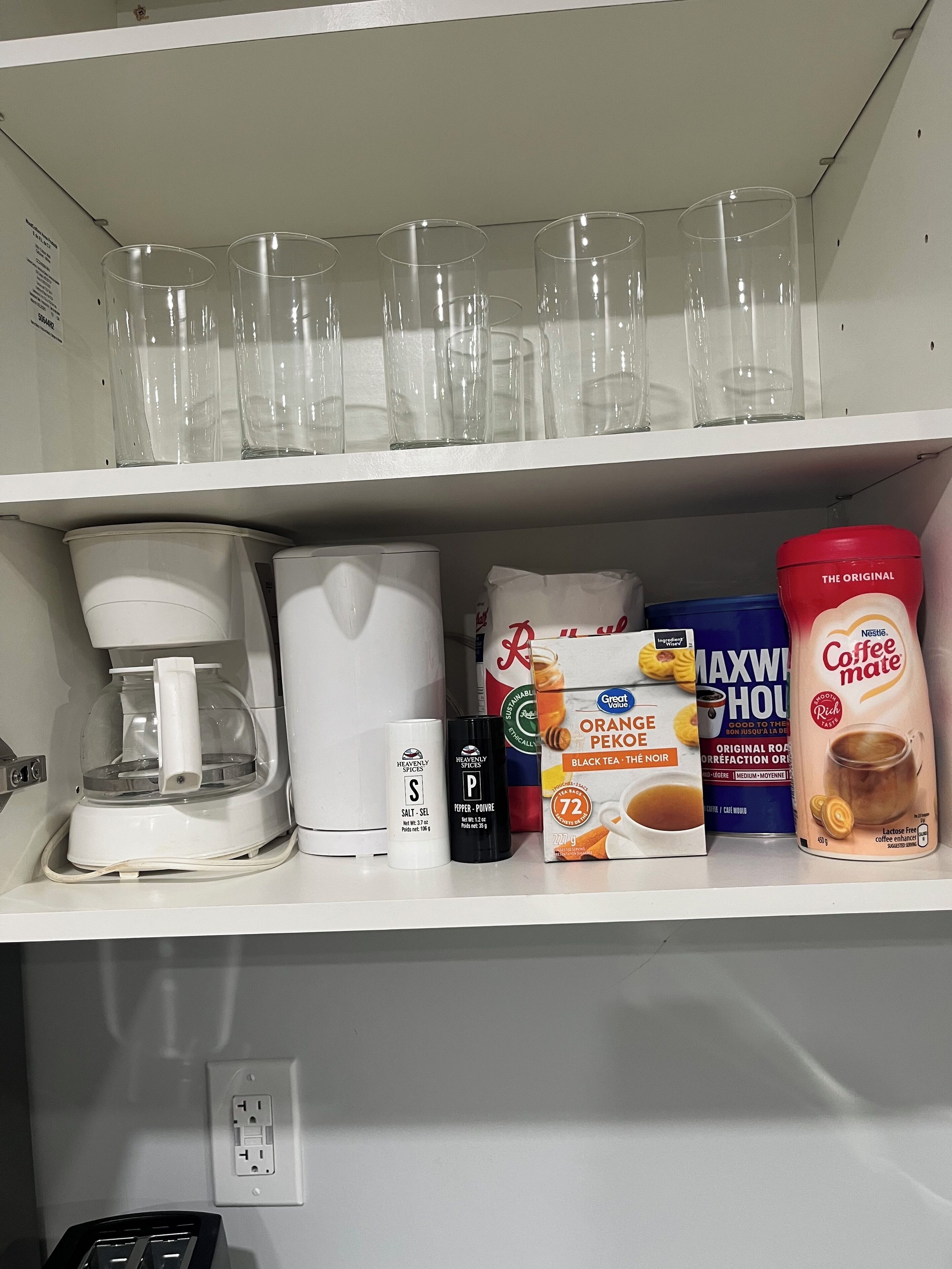 Keittiön hyllyllä on kahvinkeitin, suolaa, pippuria ja kahvikermaa.