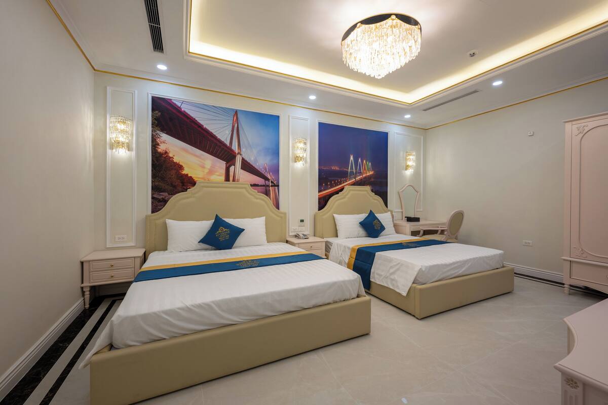 A hotel room with two beds, a desk, and a wardrobe.