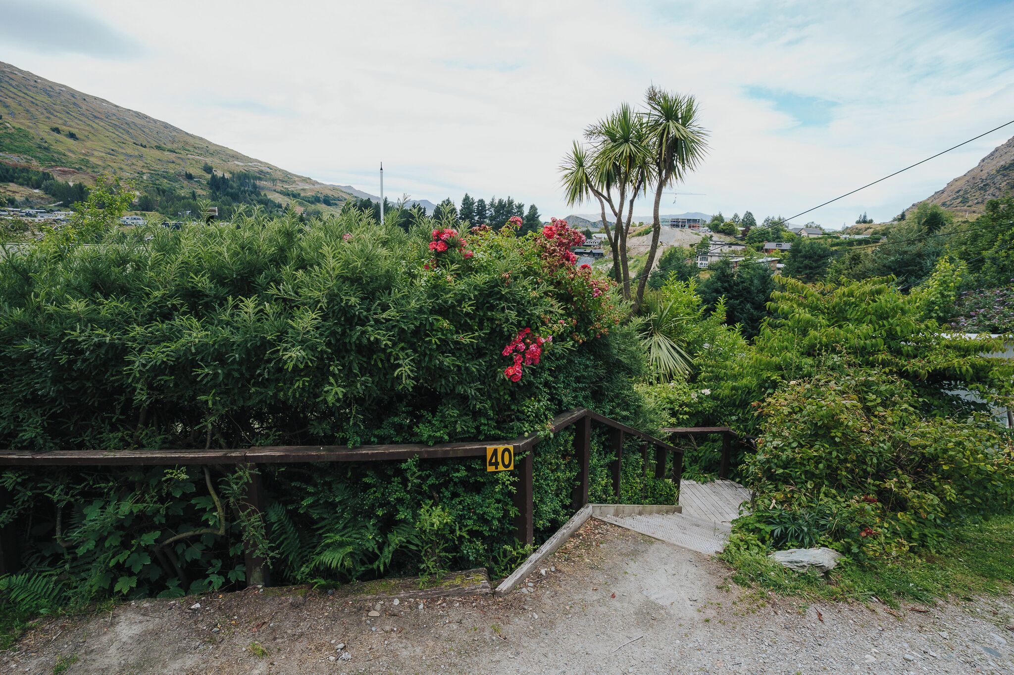 A pathway leading to a building with a wooden railing and a sign indicating a 40-meter distance.