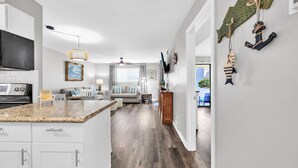 A modern kitchen with white cabinets, a granite countertop, and a built-in oven.