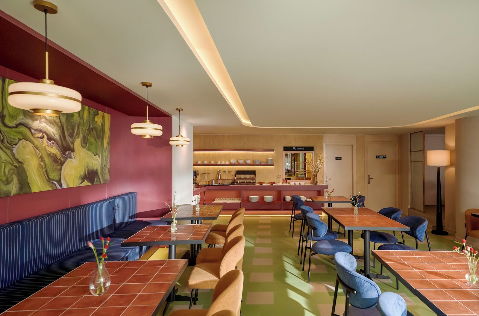 Eine moderne Hotelhalle mit Barbereich in der Mitte, Sitzgelegenheiten und einem großen abstrakten Gemälde an der Wand.