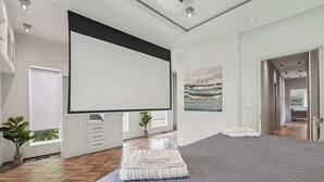 A modern bedroom with a large bed, a flat-screen TV, and a small desk area. - Near Zoo Atlanta | Modern 4BR Home, Sleeps 8 (Atlanta)