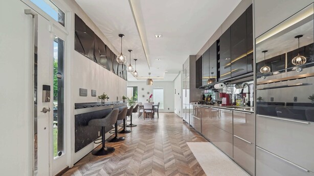 A modern kitchen with a herringbone floor pattern, stainless steel appliances, and pendant lighting. - Near Zoo Atlanta | Modern 4BR Home, Sleeps 8 (Atlanta)