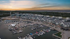 Un port de plaisance doté de plusieurs quais et abritant de nombreux bateaux, entouré de bâtiments modernes et bordé par une étendue d’eau.