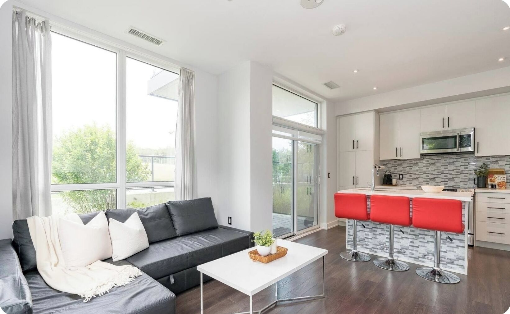 A modern apartment with a living room, kitchen, and a balcony.