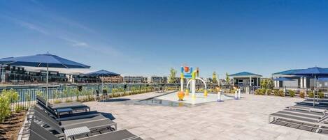 A spacious outdoor area with a pool, seating, and a playground.