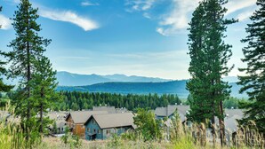 Ein Wohngebiet mit Häusern, umgeben von hohen Bäumen und Bergen im Hintergrund.