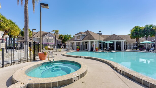 A swimming pool with a hot tub, surrounded by a fence, with houses in the background. - 2 Mi to Disney & Old Town: Resort Condo w/ Perks (Kissimmee)